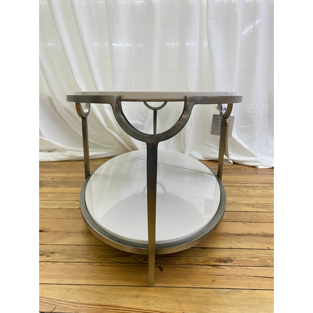 Bernhardt Morello side table featuring a faux Carrara marble top and matching lower shelf, supported by a steel frame in a...