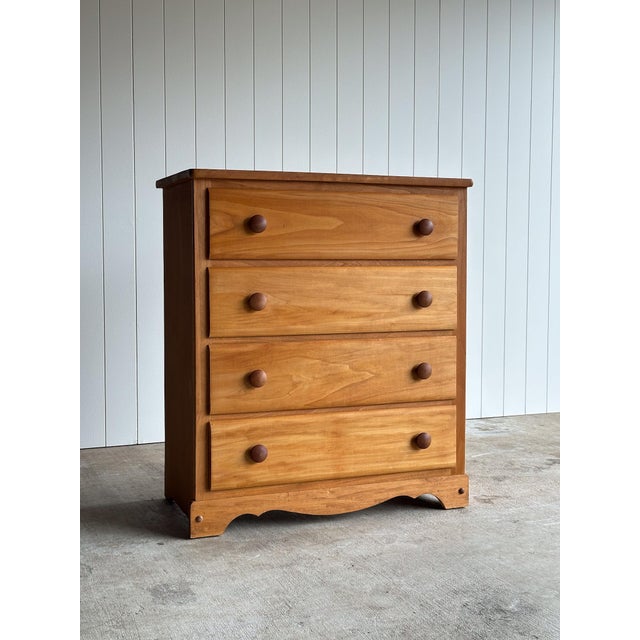 This vintage four drawer dresser features softly framed drawer fronts, turned wooden pulls, and a gently shaped apron base...