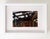 This artwork depicts the interior of a dilapidated structure, showcasing a weathered wooden framework against a soft,...