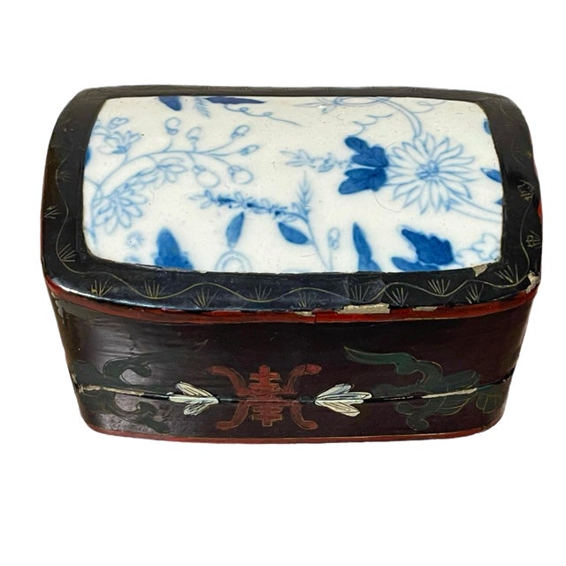 A Chinese enameled box with inlaid blue and white pottery shard on top. Hand painted Asian motifs on sides. Circa 19th...