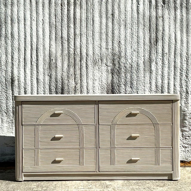 Bring coastal elegance to your home with this vintage arched pencil reed dresser. Featuring a timeless design, this piece...