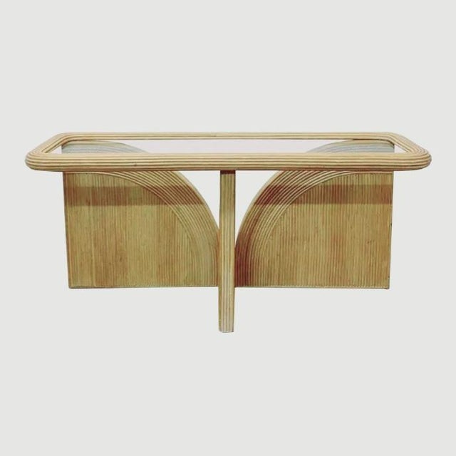 A wonderful Mid-Century modern pencil reed modern organic designed glass top console table. The table features pencil reed...
