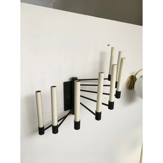 An exceptional and increasingly difficult-to-find eight-arm Lightolier wall sconce, retaining its original manufacturer...
