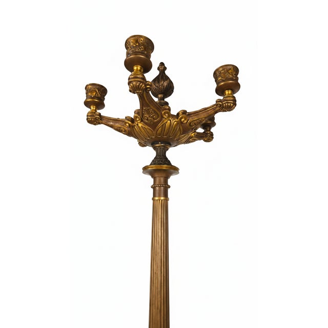 A striking pair of late 19th-century French five-light candelabra in gilt and dark-patinated bronze, each bearing three...