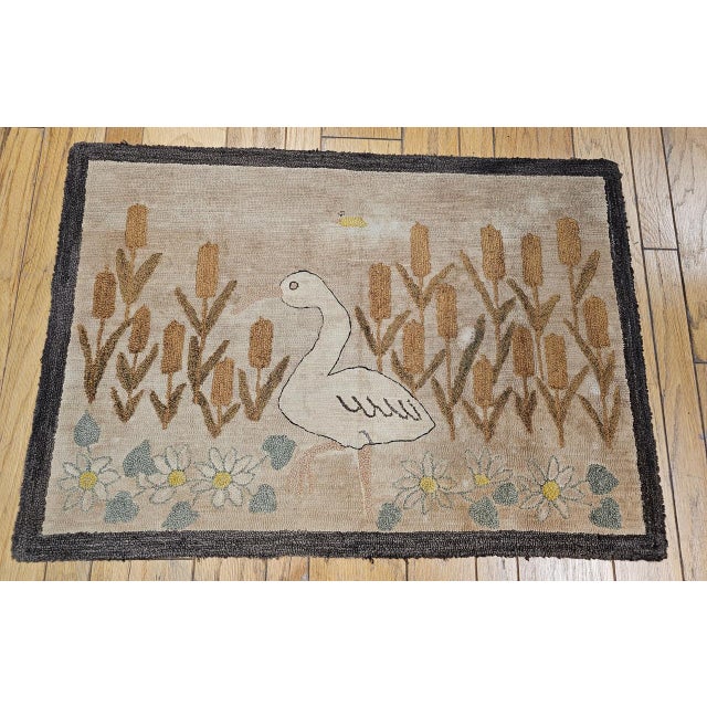 This early 20th century American hand-hooked rug features an imaginative and whimsical bird and floral design of great...