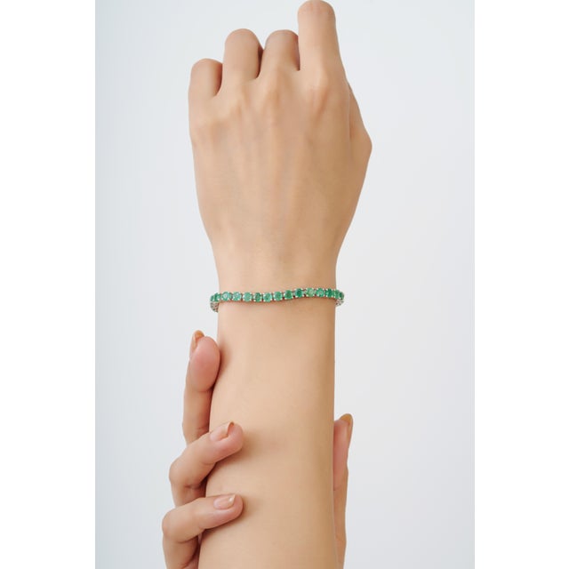 This contemporary tennis bracelet features 9.18 carats of round-cut natural emeralds, each measuring approximately 4 x 4...