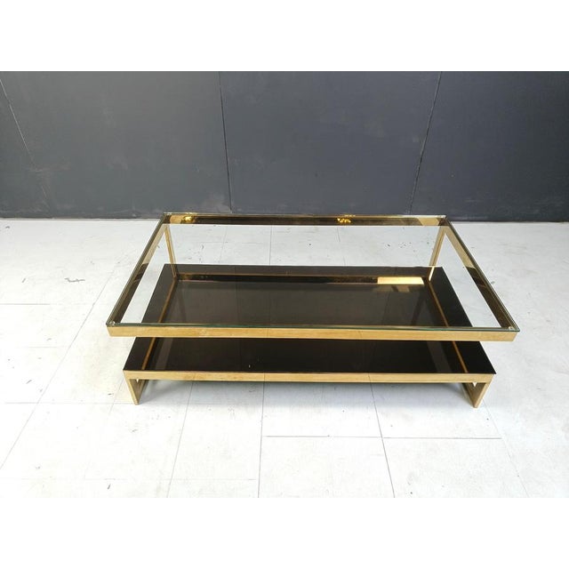 Quality 23kt gold layered and clear glass two tier coffee table manufactured by Belgochrom. This table is a popular model...
