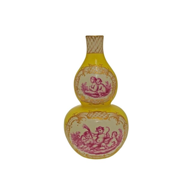 An elegant pair of double-gourd porcelain vases mounted as candlesticks, each decorated with finely hand-painted scenes of...