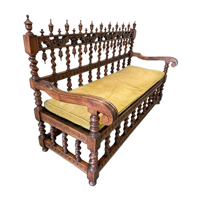 A late 19th-century Renaissance Revival settee in walnut, defined by its highly architectural spindle-back and finely...