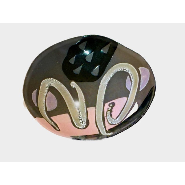 This hand-formed circular dish exemplifying the late twentieth-century Postmodern studio pottery movement features a...