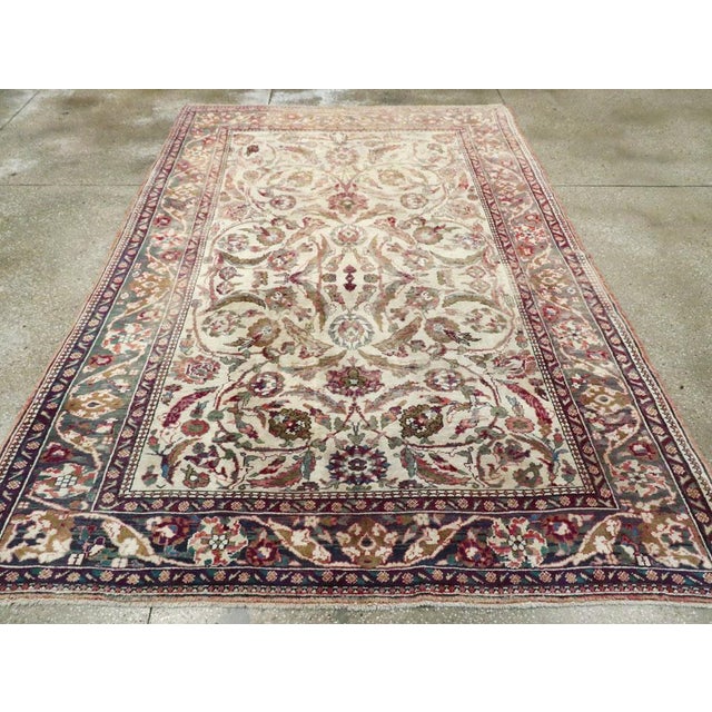 An antique Turkish Oushak accent rug. The old ivory field of this attractive west Turkish carpet has a bilaterally...