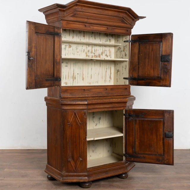 This Swedish pine cupboard has a warm aged patina due to 200 years of use. Decorative panel doors and lower canted sides...