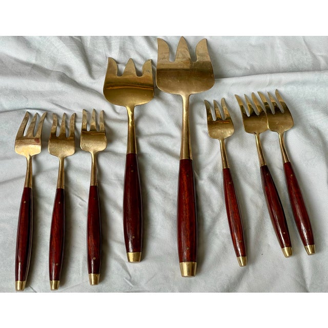 This is a beautiful set of brass flatware with rosewood handles including 2 larger serving pieces and 6 individual forks....