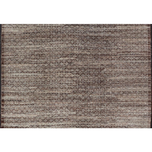 Measures: 10'1 x 131. This modern casual Khotan rug has been hand-knotted. The rug features a modern all-over geometric...