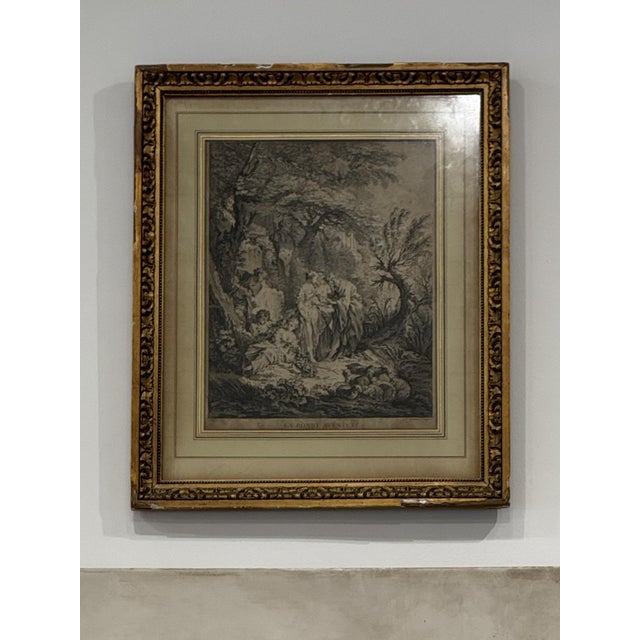 Beautifully framed European landscape engraving depicting a tranquil woodland scene with figures gathered along a winding...