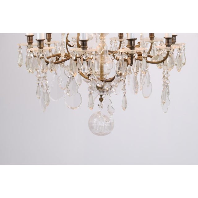 Antique chandelier / crystal chandelier from around 1920, designed with prisms and gilt bronze decorations. The chandelier...
