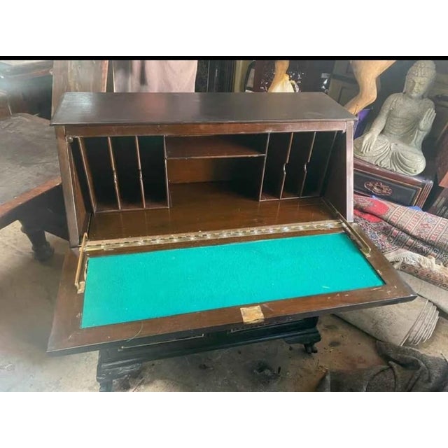 Wood bureau chest with fall front top, 2 drawers and writing surface. Carved detail . Also a Secret drawer