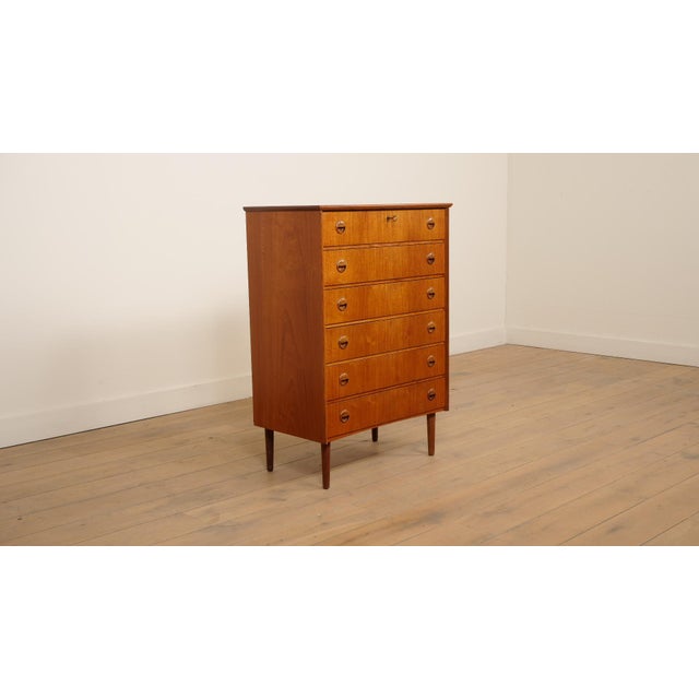 Danish vintage chest of drawers that stands out for its beautiful sleek design. The simple, clean yet playful handles on...