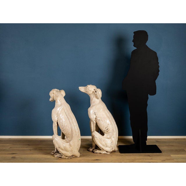 An elegant pair of greyhounds crafted from Tuscan white porcelain, dating back to the early 20th century. The sculptures...