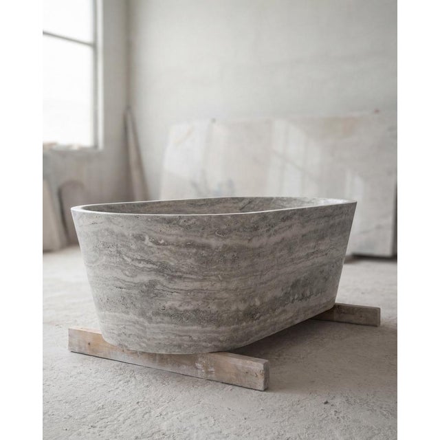 Cova Stone Bath – Sculpted Solid Silver Travertine Bathtub: The Cova Stone Bath is a monolithic bathtub carved from a...