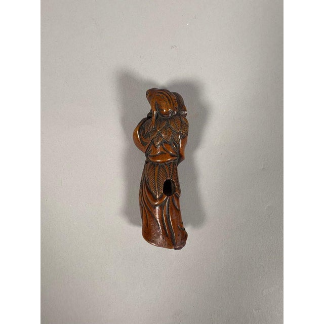 Early 18th-century wooden netsuke, Edo period. The netsuke is depicted as a Noh mask, an old sage carrying a toad on his...