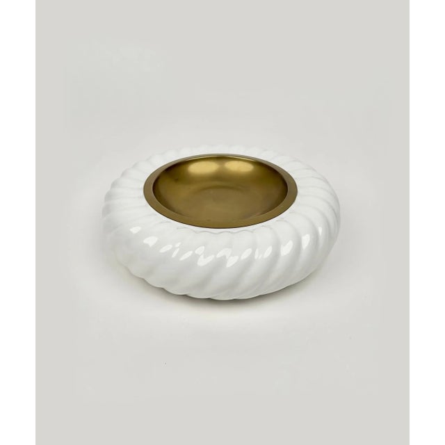 Amazing round ashtray or vide-poche in white ceramic and brass by the Italian designer Tommaso Barbi for B ceramiche. Made...