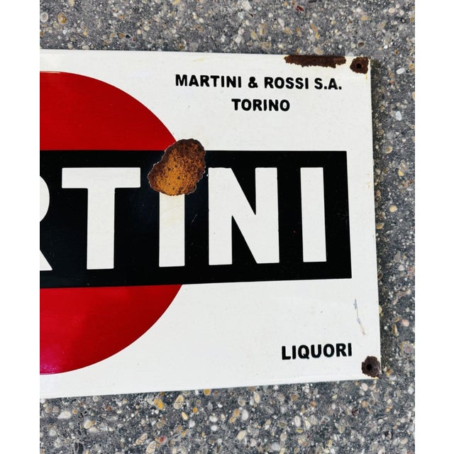 Enameled iron martini sign with signs of rust due to time.
