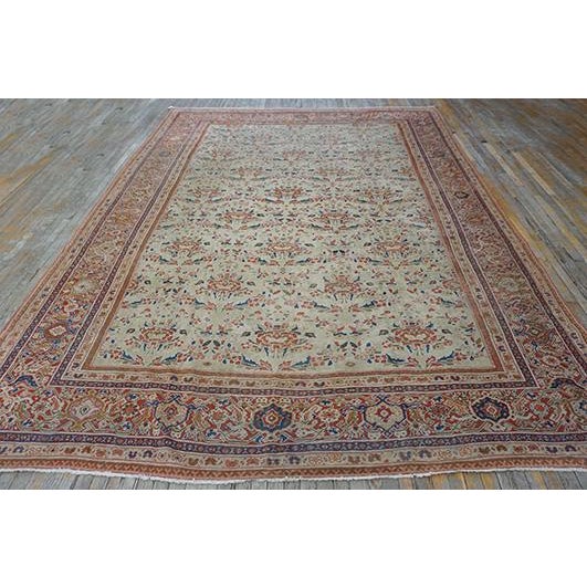 This antique Persian Mahal rug dated to circa 1925, features a beige ground with a wool composition measuring 9' 5" x 12'...