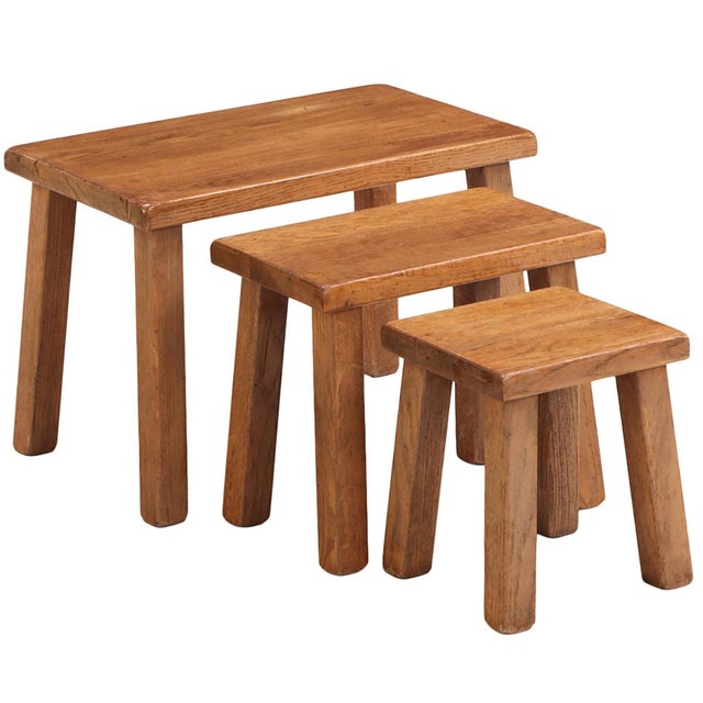 A handsome set of three French Brutalist nesting tables crafted in solid oak, showcasing the bold simplicity and organic...