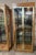 Pair of brass and glass display cabinets or vitrines style of Mastercraft. These chic and elegant cabinets are in...