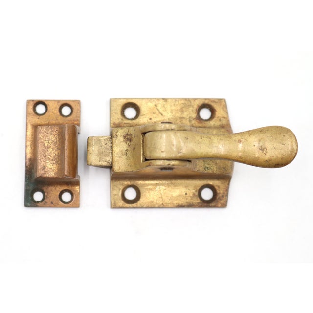 Antique transom window latch made of brass with a spring loaded lever. The original mounting screws are not available....