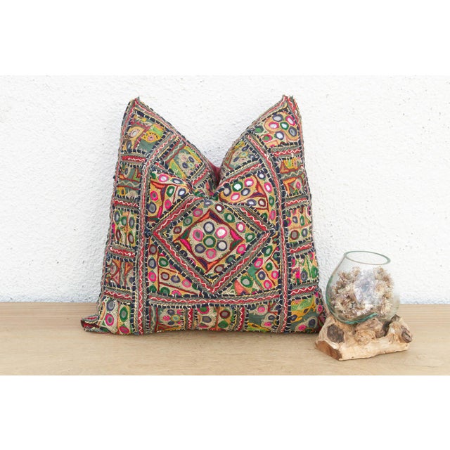 This 16-inch square pillow is a breathtaking fragment of Rajasthani heritage, repurposed from antique Banjara textiles...