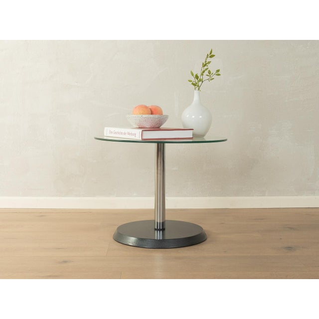 Postmodern side table from the 1980s. Chrome-plated metal frame with a glass tabletop and a metal base. Quality features:...