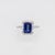 A tanzanite sits in a deep violet-blue at the centre of this solid 14K white gold ring, encircled by thirty-six earth-...