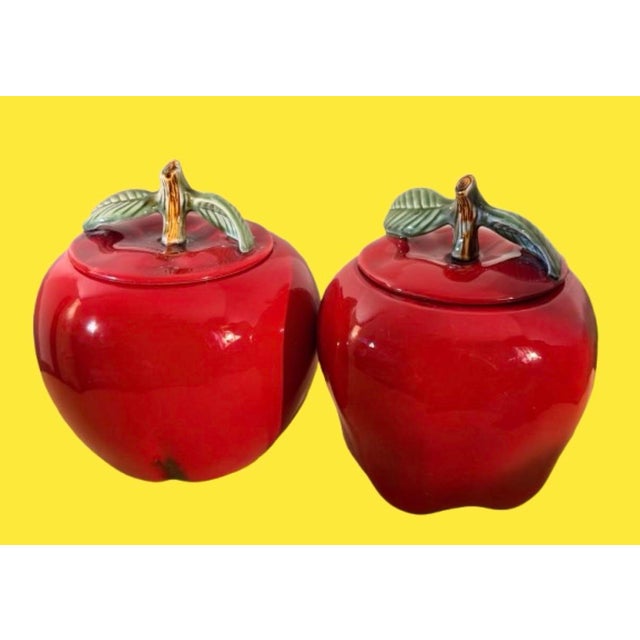 Vintage California glossy red ceramic apples shaped storage canister featuring a detailed green leaf and stem lid. There’s...