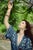 Wisteria by Nadezda | Oil on Panel Woman reaching for blooming wisteria flowers. For Sale