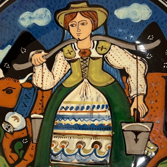 Rare - large art pottery charger handcrafted and painted by Hans Schneider-Kraft (1923- 2006). Depicting a Swiss milk...