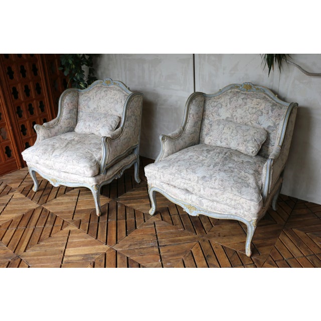 Evoking the romance of Mid 20th Century France, this exquisite pair of Louis XV-style wingback bergère armchairs captures...
