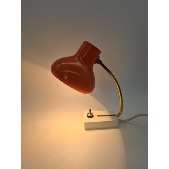 This desk lamp from the 1970s is built on a distinctive, compact design: an orange metal shade with a semi-matte finish...