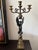 A dramatic pair of mid‑20th‑century Classical Revival candelabra featuring sculptural winged figures supporting ornate...