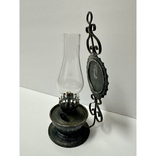 Small rustic metal oil lantern. Glass chimney. Approximately 3” x 8”.