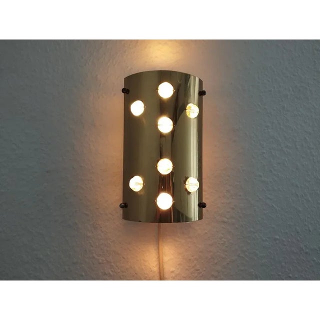 The charming brass wall lamp with faceted acrylic balls has two sockets for E14 bulbs and can be mounted on the wall both...
