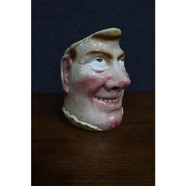 French ceramic character pitcher by Sarreguemines, featuring a sculpted male face with exaggerated features, rosy cheeks,...