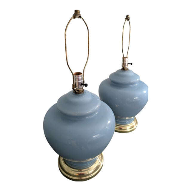 A classic vintage pair of large ginger jar table lamps featuring glossy powder-blue ceramic bodies and polished brass-tone...