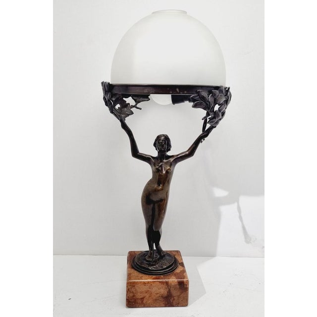 Art Nouveau bronze table lamp, crafted in the 1920s. Characterized by an ornate, organic design with flowing lines, a...