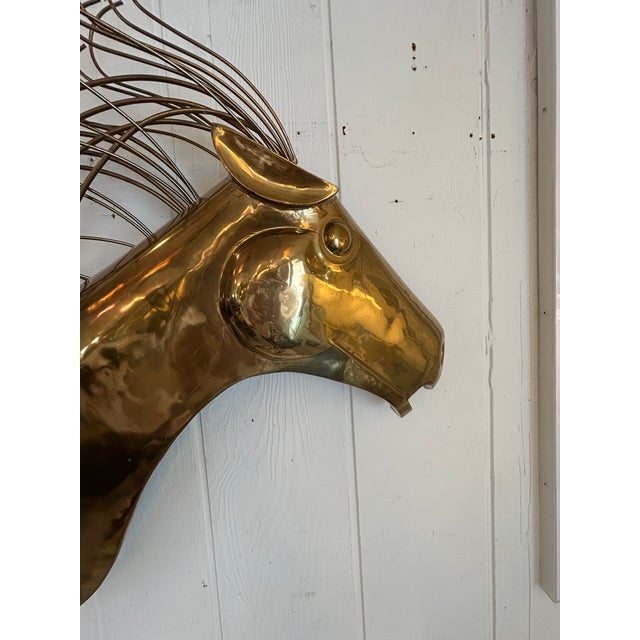 Stylized brass horse head wall sculpture by Curtis Jere having a distinctive flowing mane constructed of bent brass rods....