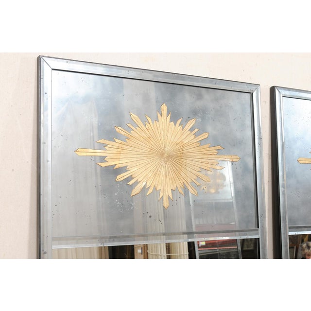 A pair of tall American artisan crafted mirrors with gold verre églomisé sunburst set within upper center within a...