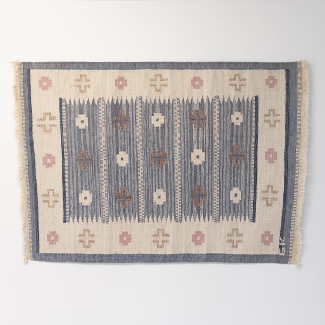 Mid-Century Swedish kilim in beige and blue with hints of pink. Signed GK. Sweden circa 1960. All our rugs undergo a...