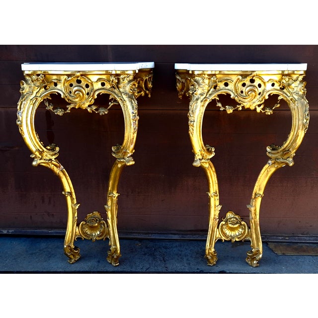 Pair of 18th Century Rococo Style Carved Giltwood Marble Top Side Tables Measures 23" in width, 14" in depth and 35" in...