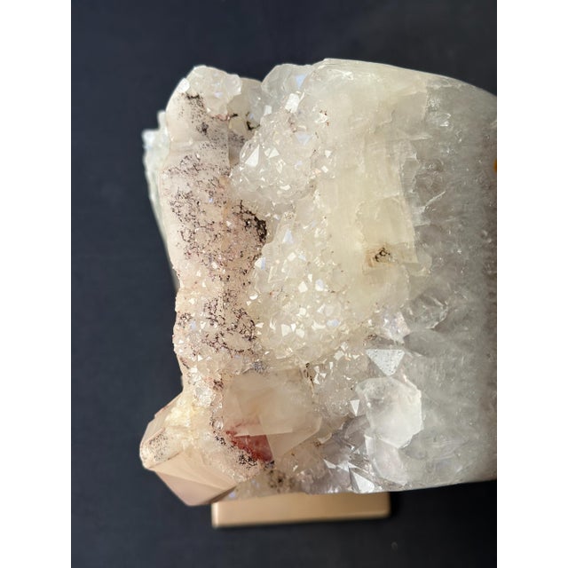 Natural quartz crystal specimen displayed on a custom golden metal stand, transforming a remarkable geological formation...
